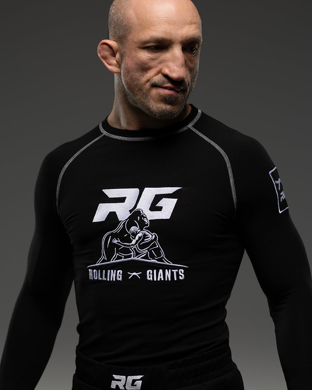 Black RG NaturaFlex™ rash guard by Rolling-Giants with long sleeves, shown on a model for sports or outdoor activities.