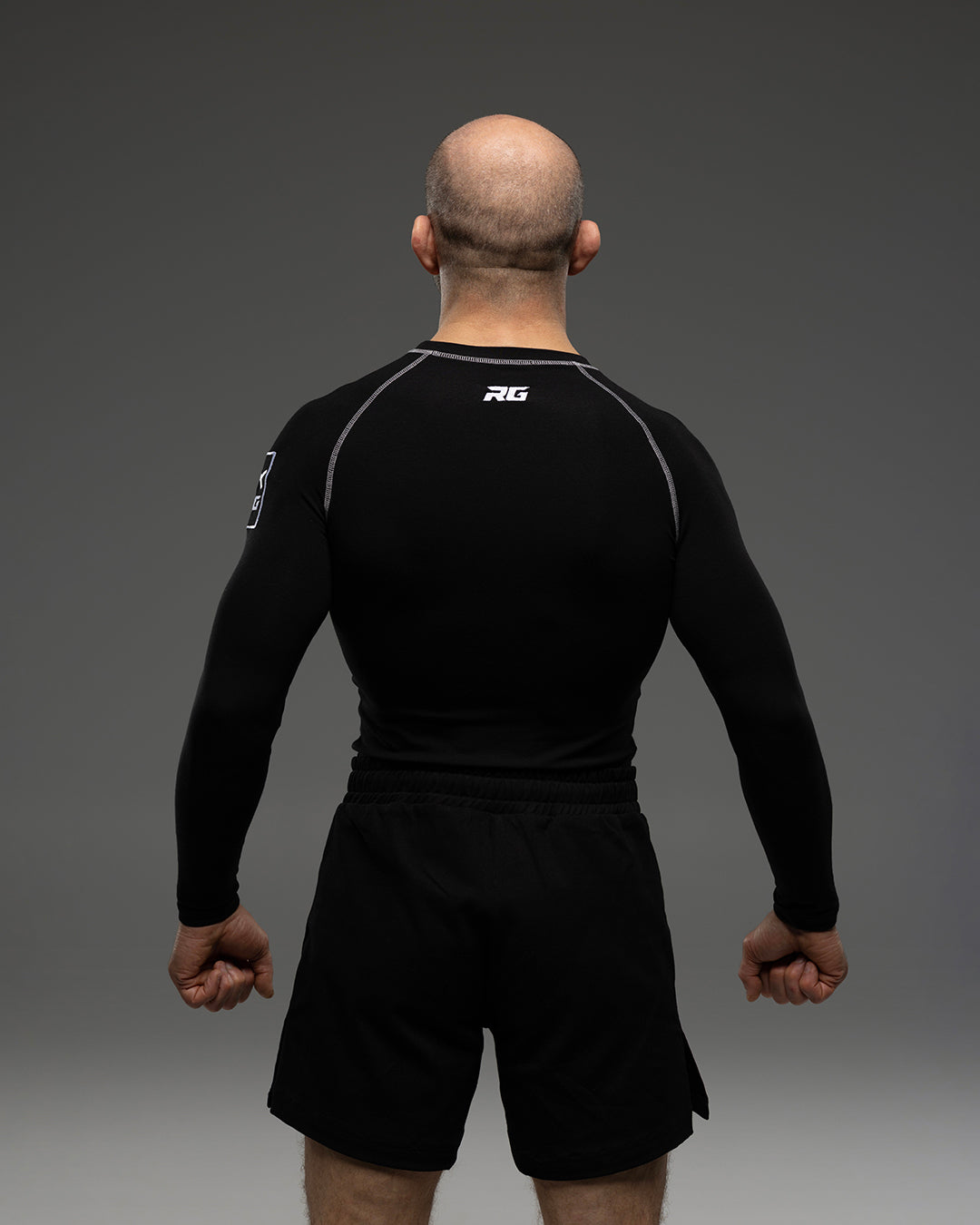 Black RG NaturaFlex™ rash guard by Rolling-Giants with long sleeves, designed for athletic performance and sun protection.
